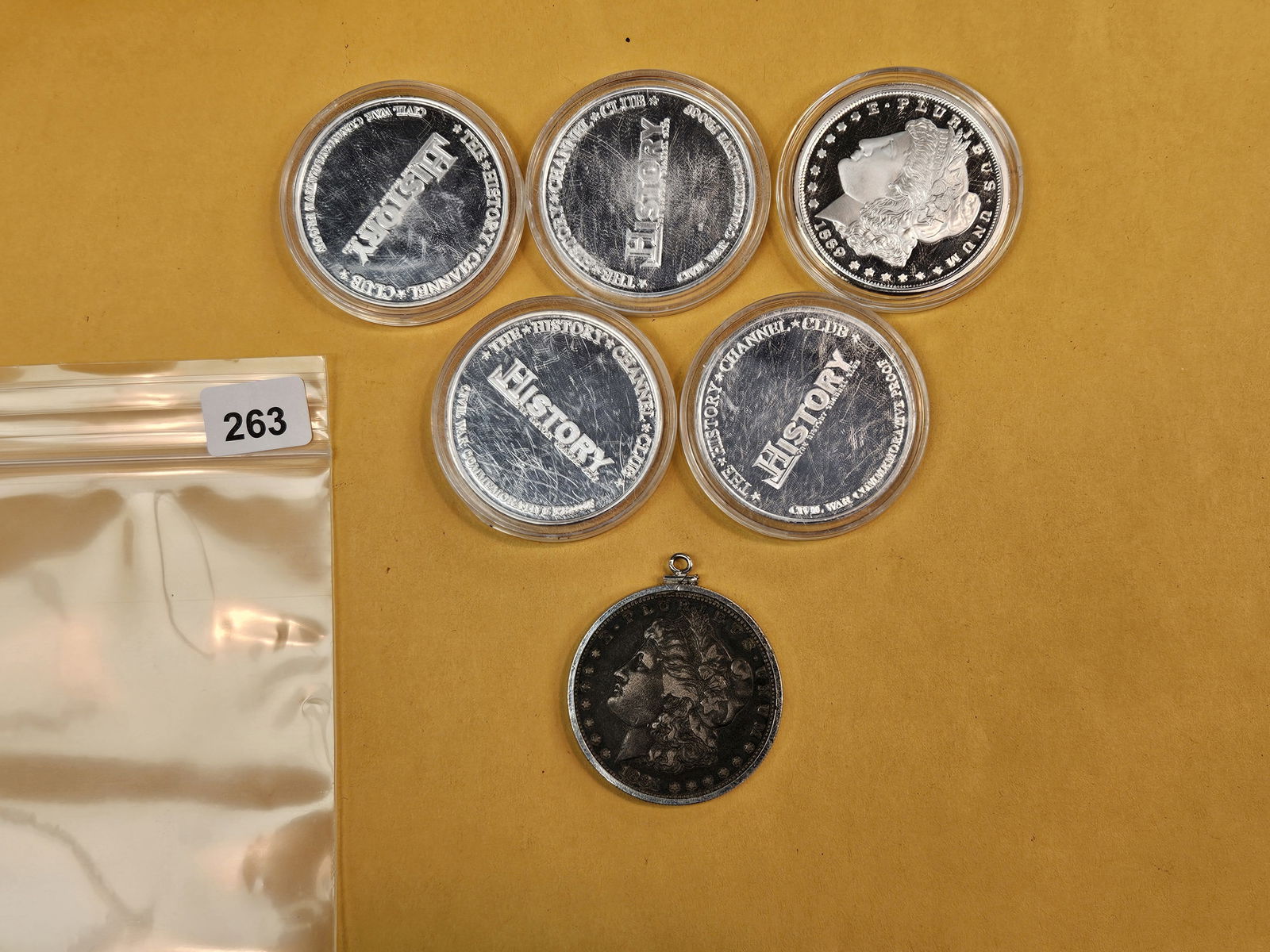 One Morgan silver dollar and Five Proof silver-plated medals: The Morgan is in a bezel 