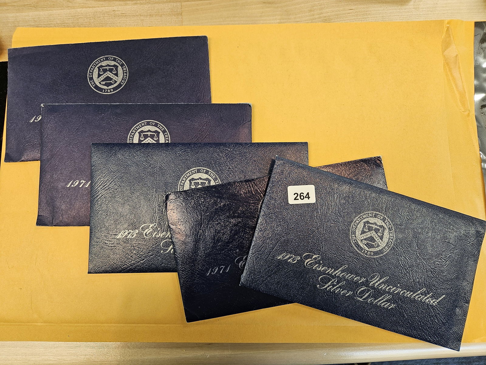 Five GEM Brilliant Uncirculated SILVER Blue Ikes: Silver Eisenhower Dollars in Blue envelopes. In original blister packs 