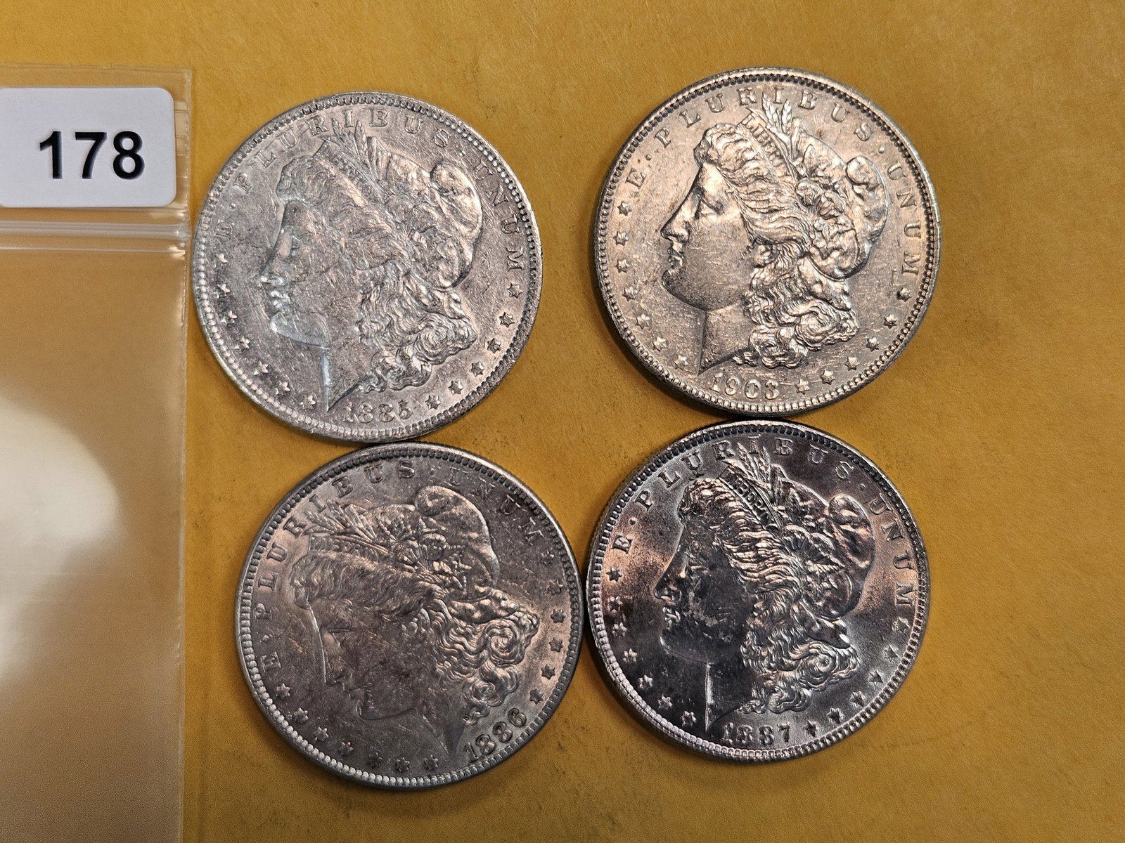 Four About Uncirculated Morgan Silver Dollars: Mixed 