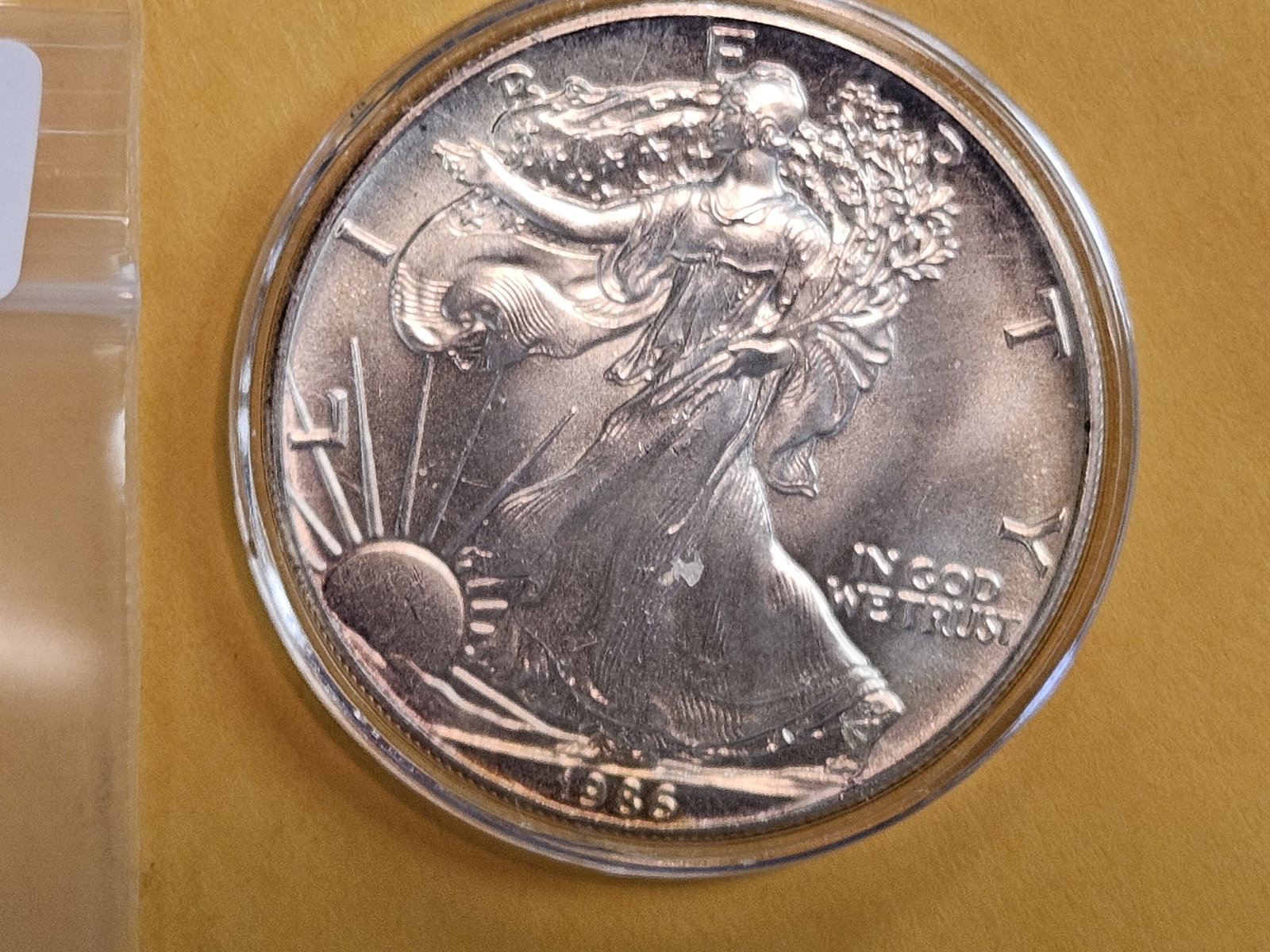 KEY DATE! GEM Brilliant Uncirculated 1986 American Silver Eagle: In original plastic capsule…lightly toned 