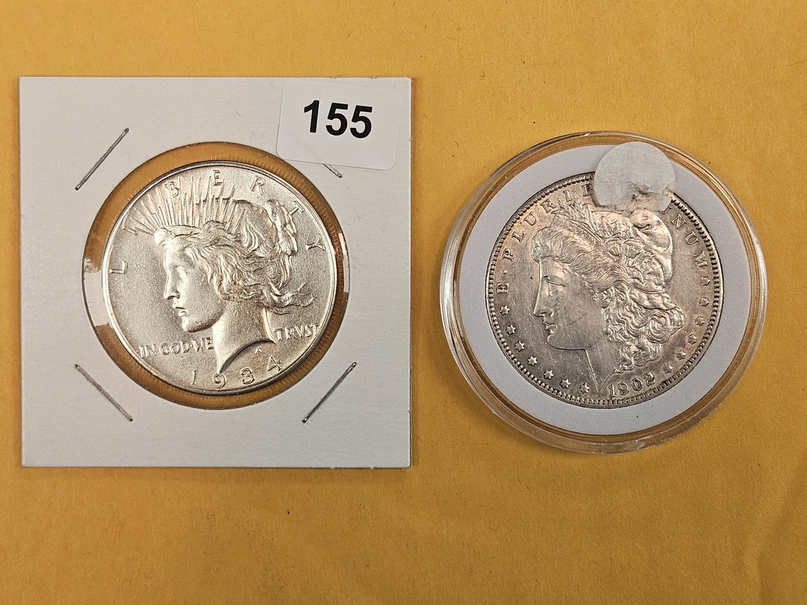 Morgan and Peace silver Dollars in About Uncirculated plus: 1934 and 1902-O