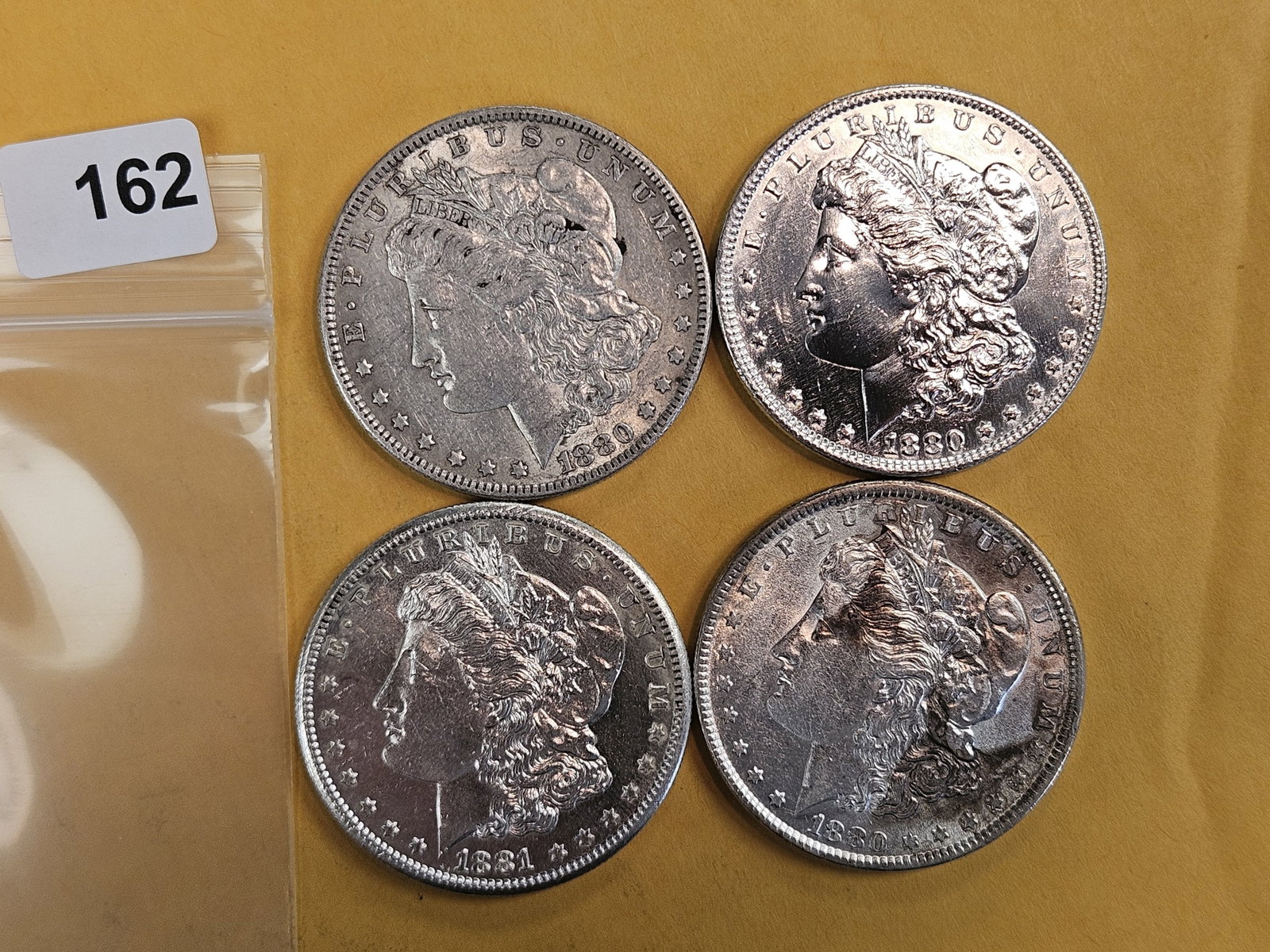 Four About Uncirculated Morgan Silver Dollars: Mixed