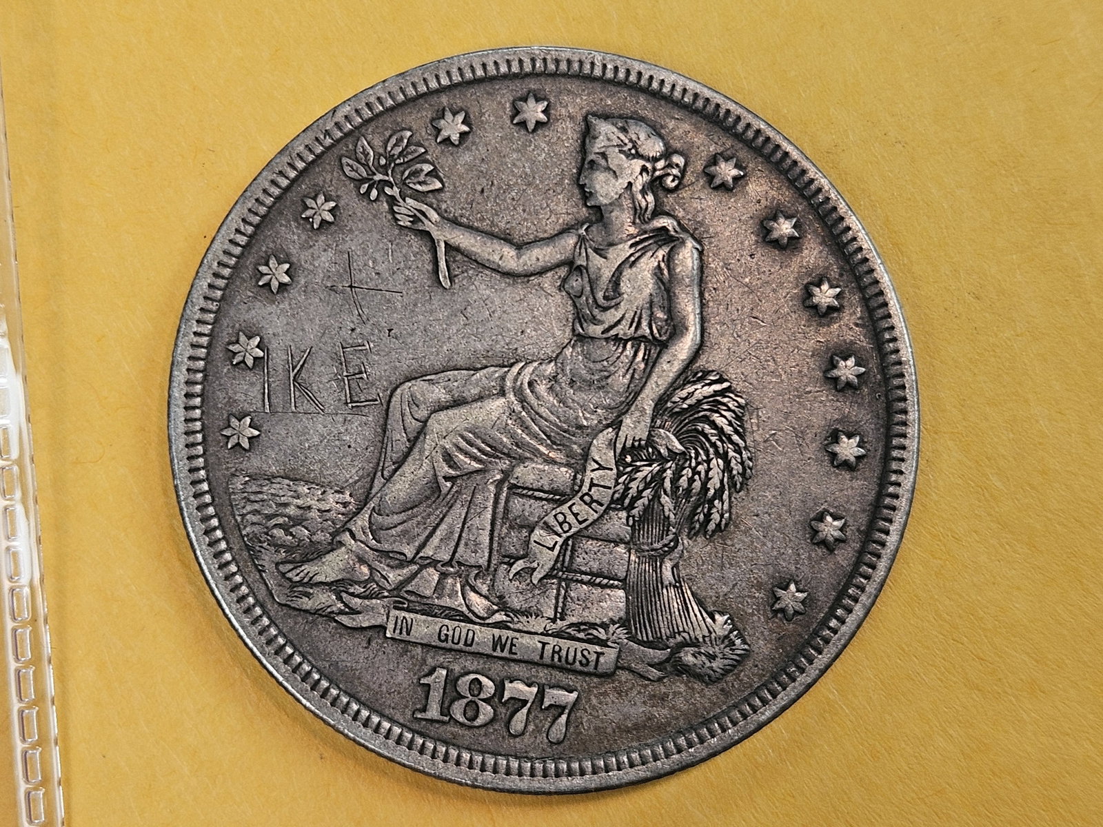1877 Trade silver Dollar in Extra Fine - details: Old grafitti says "ike". Could it have been Mr. Eisenhowers'??