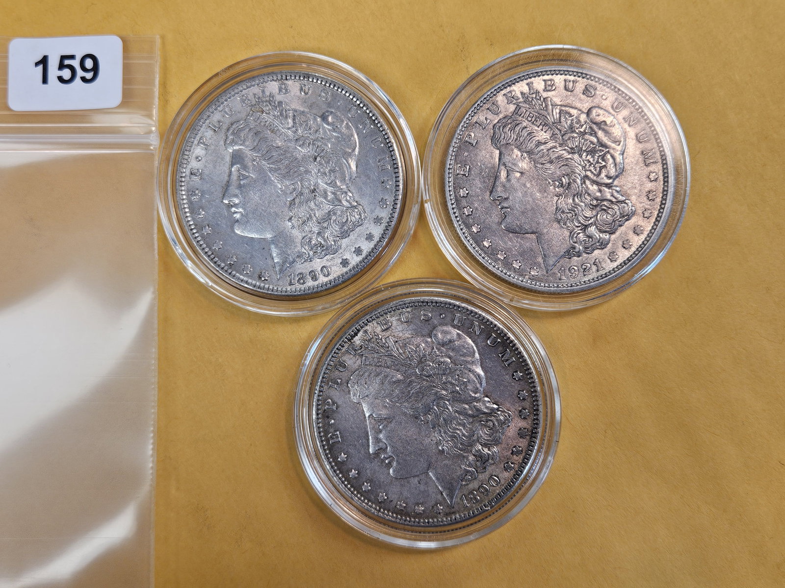 Three mixed Morgan silver dollars: All in About Uncirculated