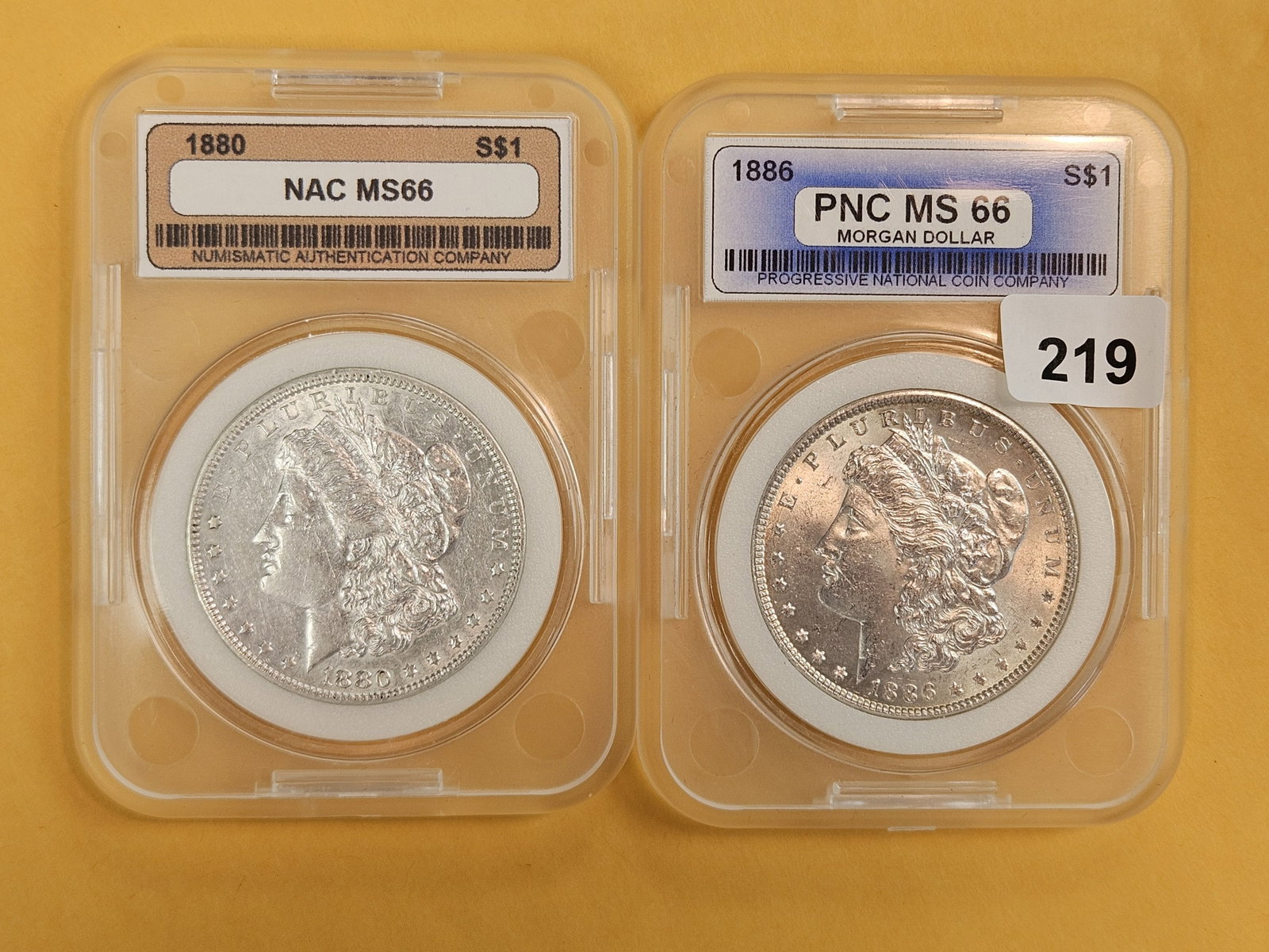 1880 and 1886 Morgan Silver Dollars: Both in off-brand holders and look Brilliant AU plus