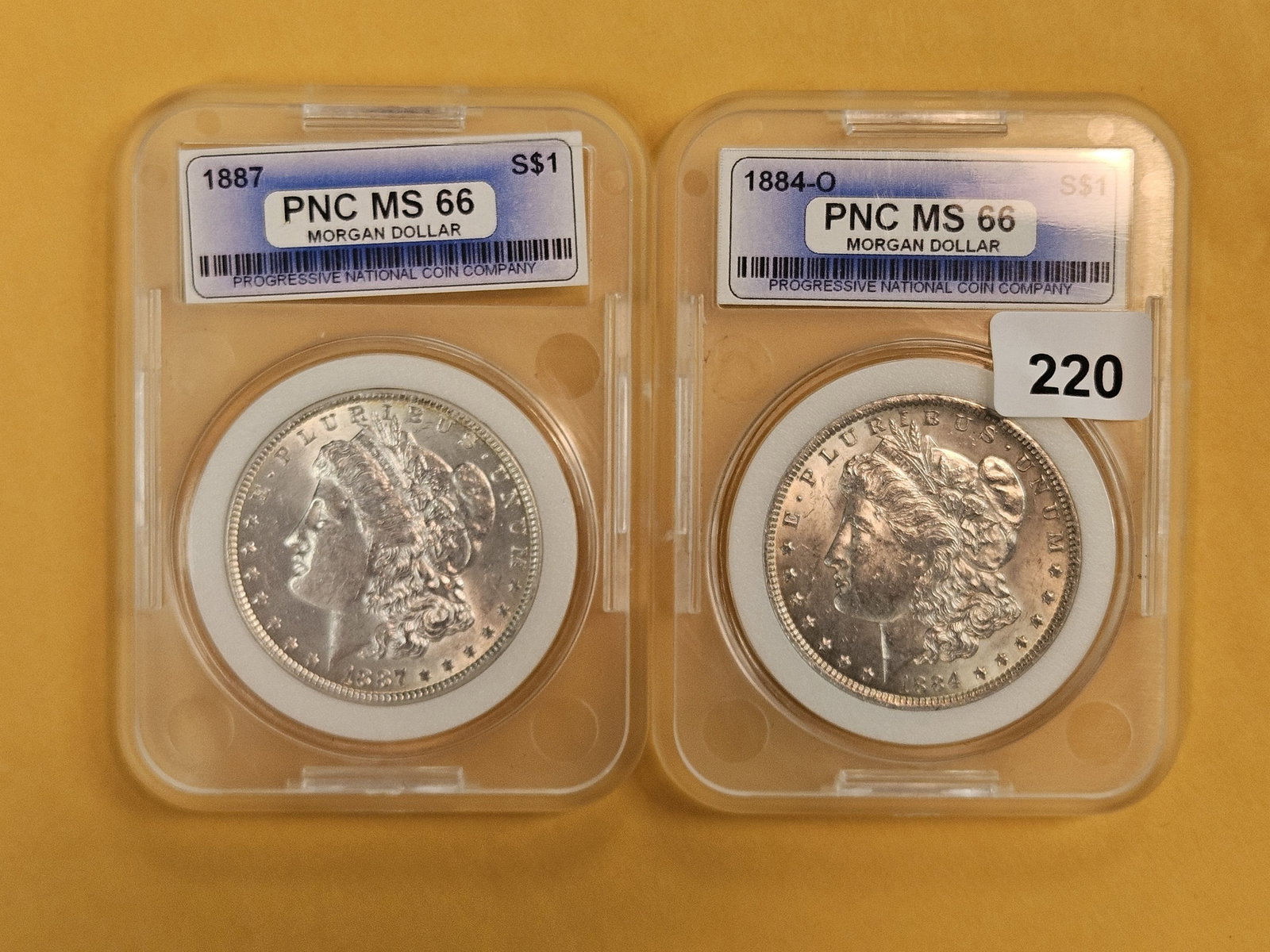 1887 and 1884-O Morgan Silver Dollars: Both in off-brand holders and look Brilliant AU plus
