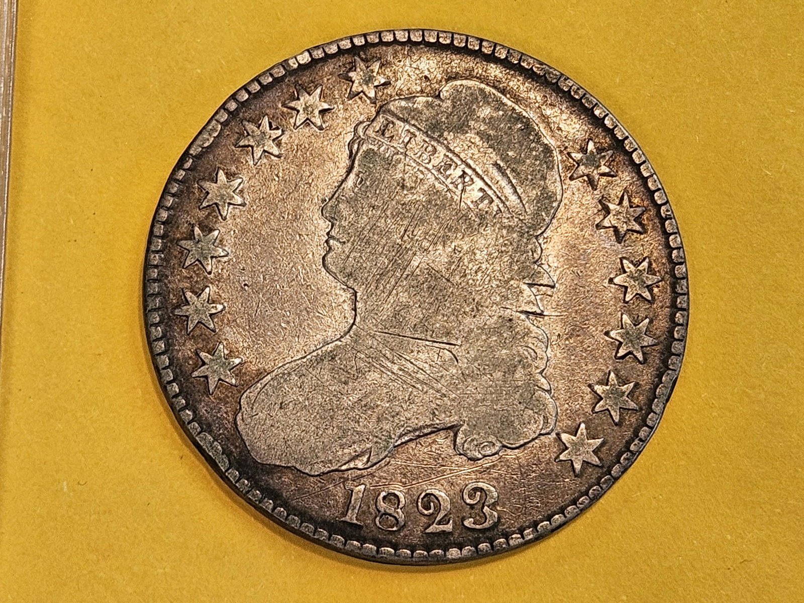 1823 Capped Bust Half Dollar in Very Good plus: Has the Overton O-101 note on the flip.