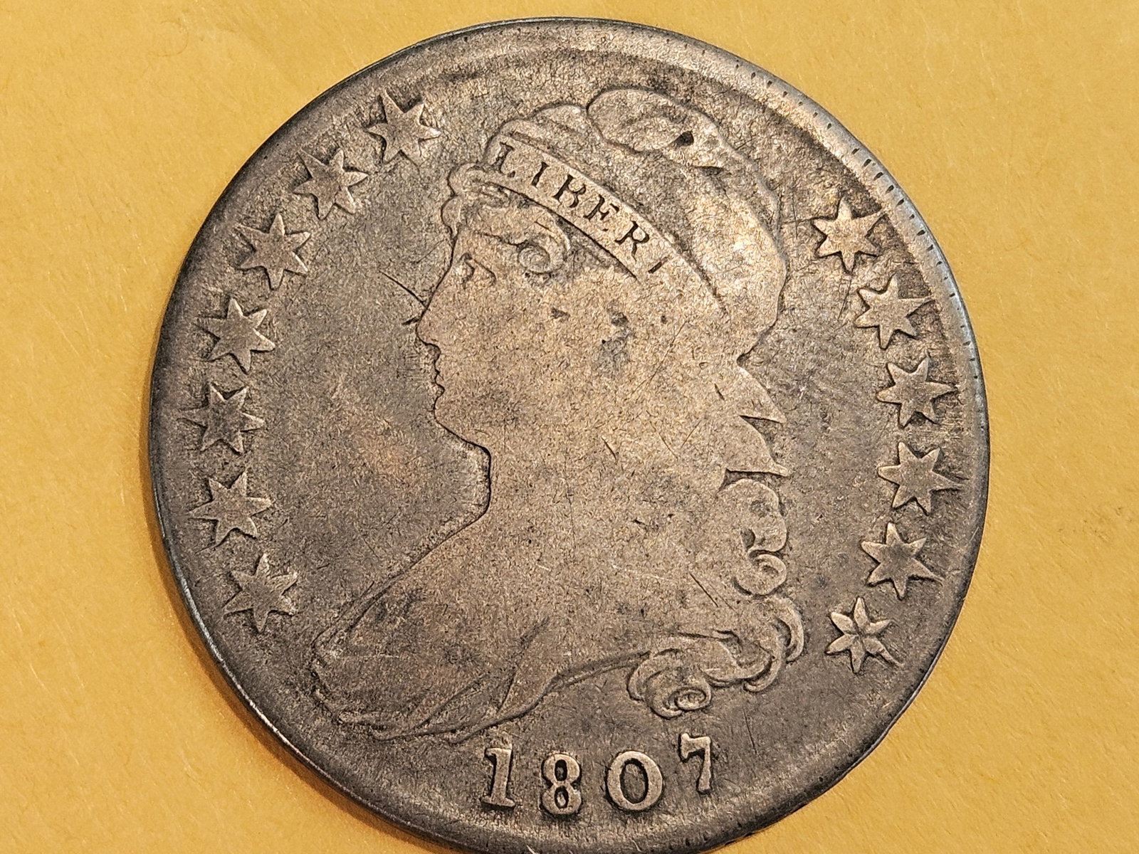 Variety! 1807 Capped Bust Half dollar in Very Good: 1807 50/20 CAPPED O-111a. Diagnostics: Numeral 5 in the denomination was punched over an inverted 5, though the underlying numeral is traditionally called a 2. A die crack extends from Liberty's neck 