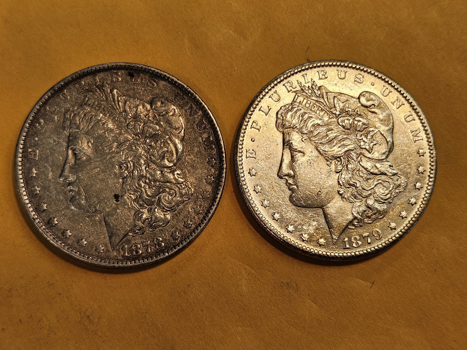 Two About Uncirculated Morgan silver Dollars: Mixed.