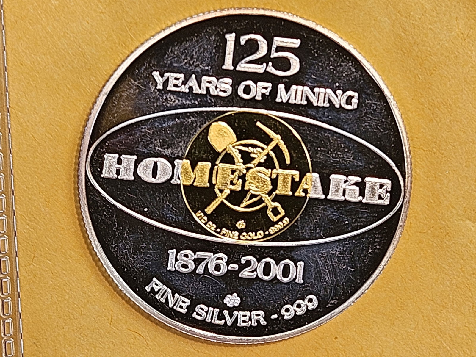 GOLD! Cool Bi-metal Gold & Silver coin: USA Homestake 2001 Bimetal Medal 125 Years of Mining. Obverse: Mining symbols. Reverse: Homestake Logo at centre. Putiry: 99.90% Weight: 12.338g Diameter: 33.06mm Nett: 0.3935ozt. Total Gold Weight: 0
