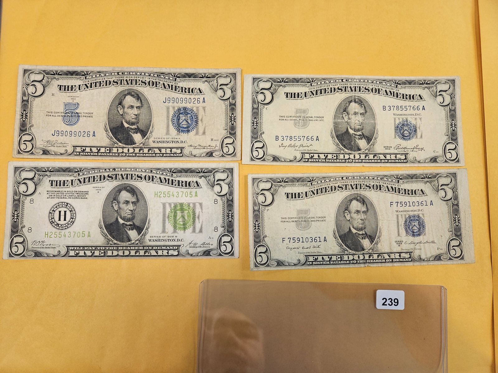 Four mixed $5 US pieces of currency: Silver Certificates and a 1928-B FRN