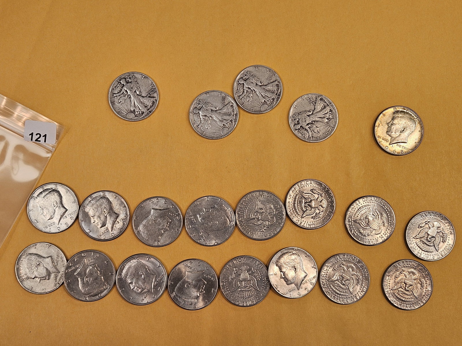 Twenty-one mixed half dollars: Four silver Walking Liberty, one 40% Silver Kennedy and sixteen clad Kennedy