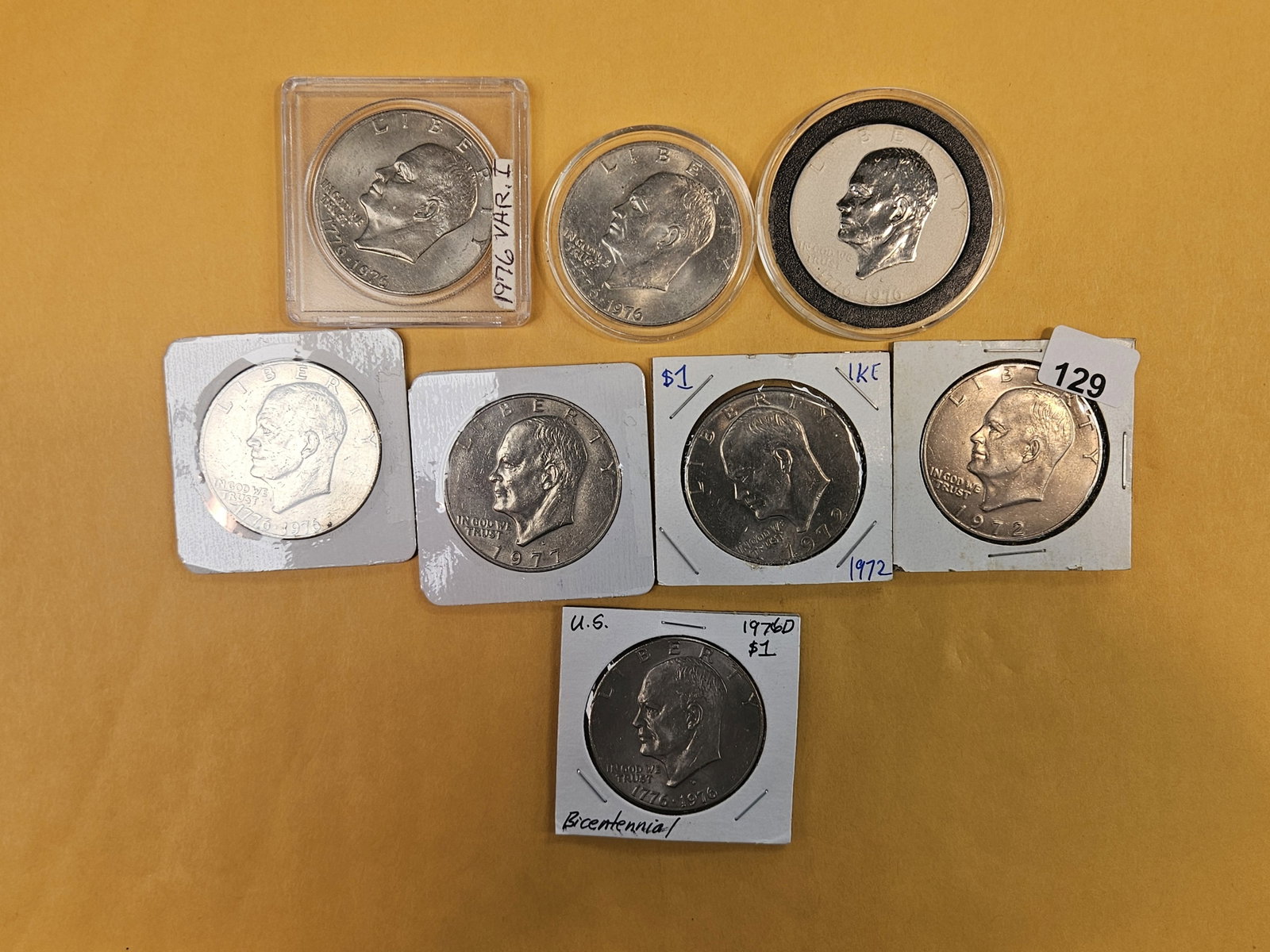 Eight mixed Eisenhower Dollars: All clad. One has been plated