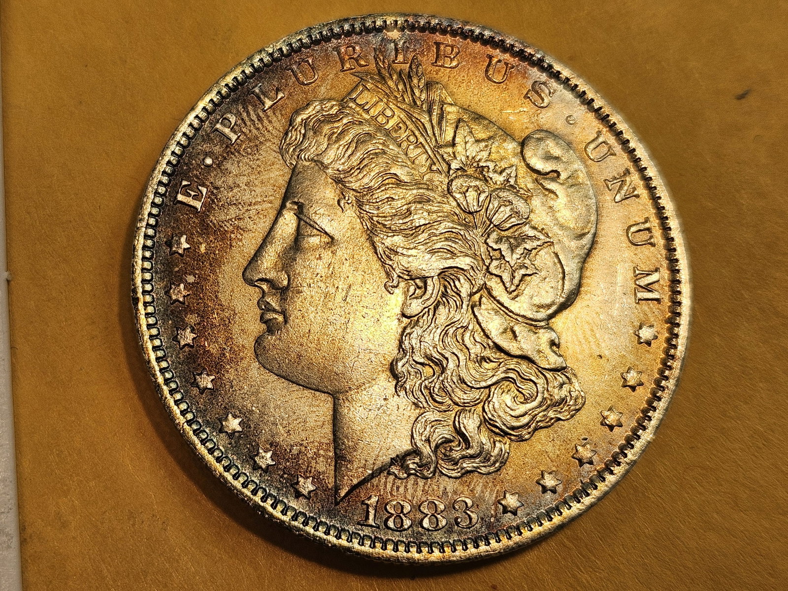 Stunning! Very Choice to GEM Brilliant Uncirculated 1883-O Morgan Dollar: Gorgeous rainbow-esque toning on the obverse!