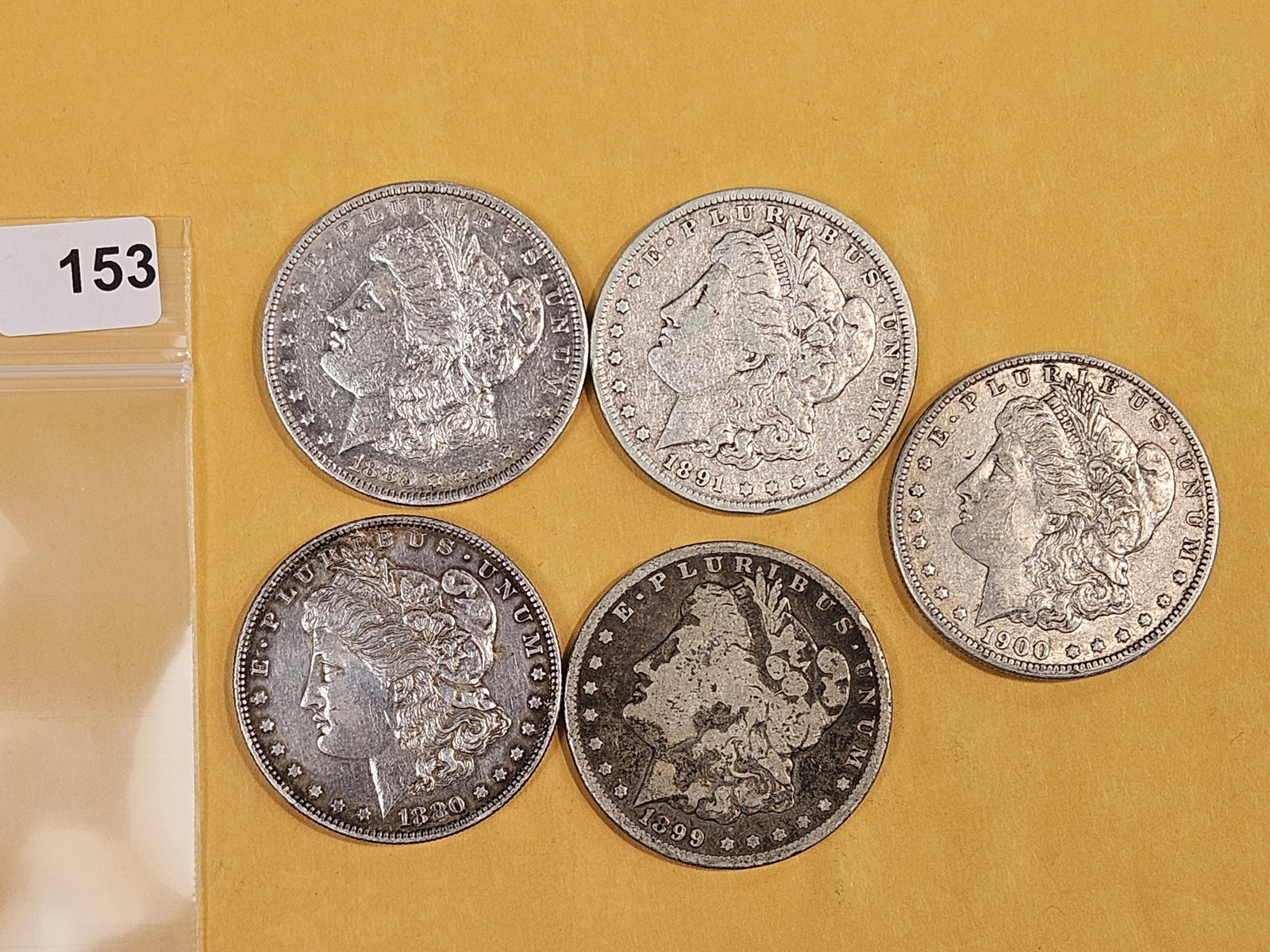 Five Morgan Silver Dollars: Mixed dates and grades