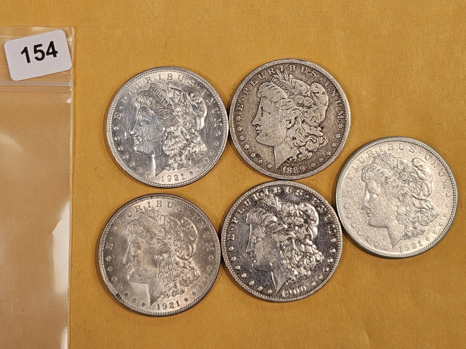 Five Morgan Silver Dollars: Mixed dates and grades