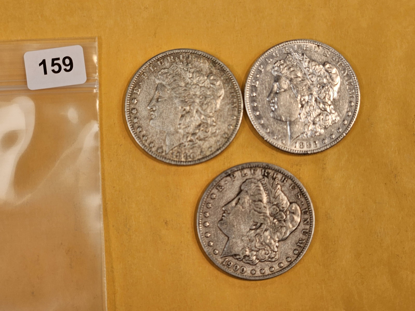 Three Morgan Silver Dollars: Mixed dates and grades