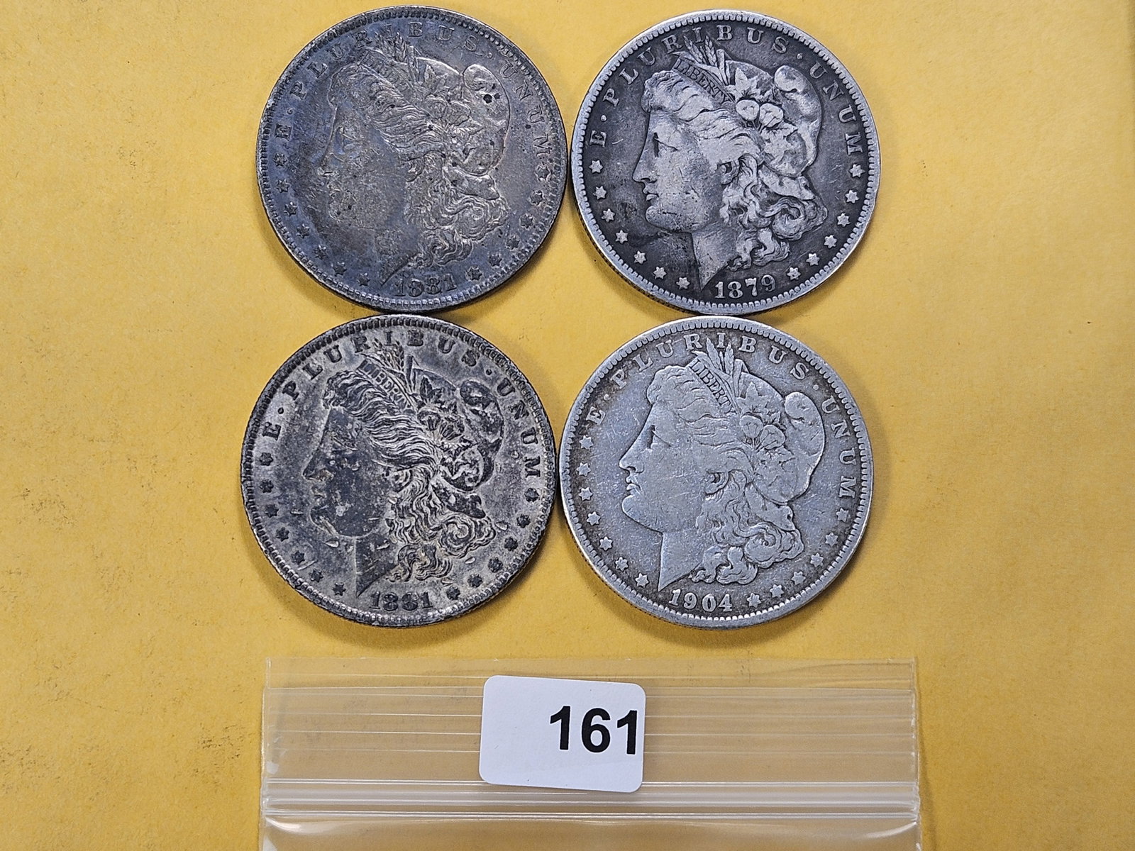 Four Morgan Silver Dollars: 1879, two 1881 and a 1904