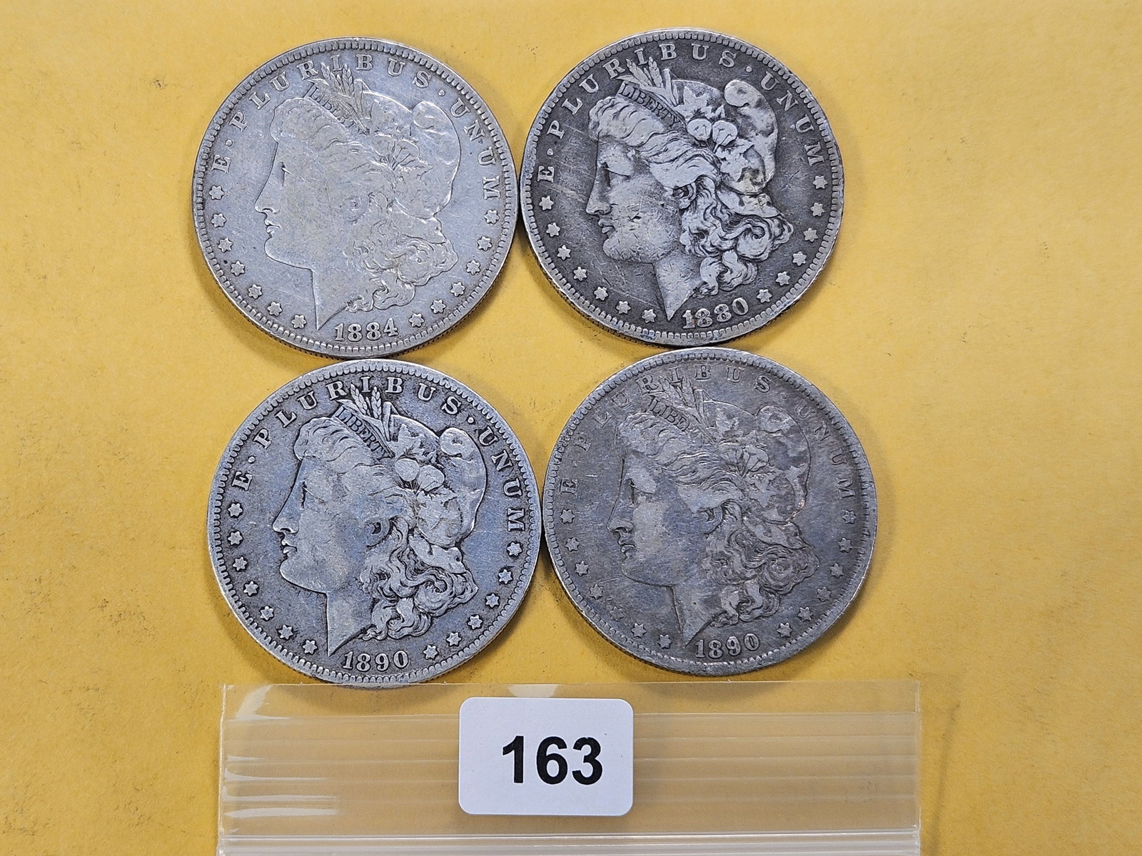 Four Morgan Silver Dollars: 1880-O, 1884 and two 1890-O