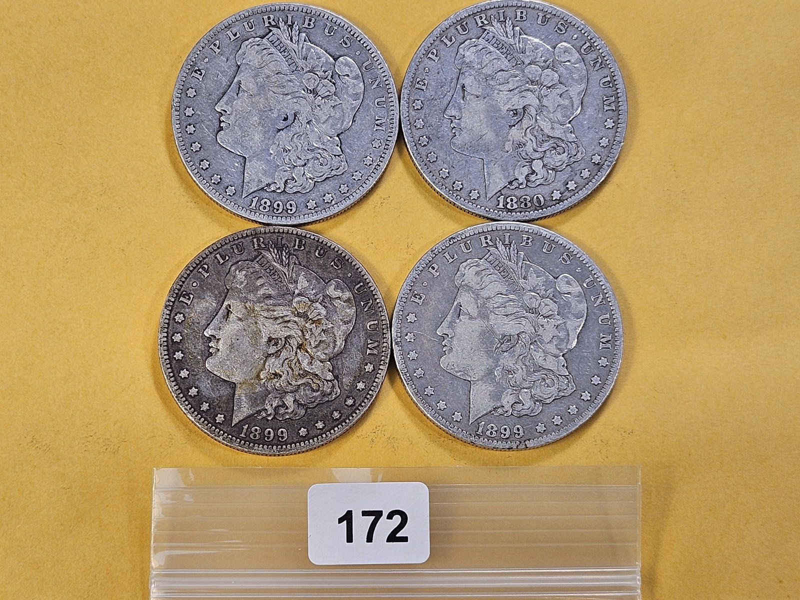 Four Morgan Silver Dollars: 1880-O and three 1899-O