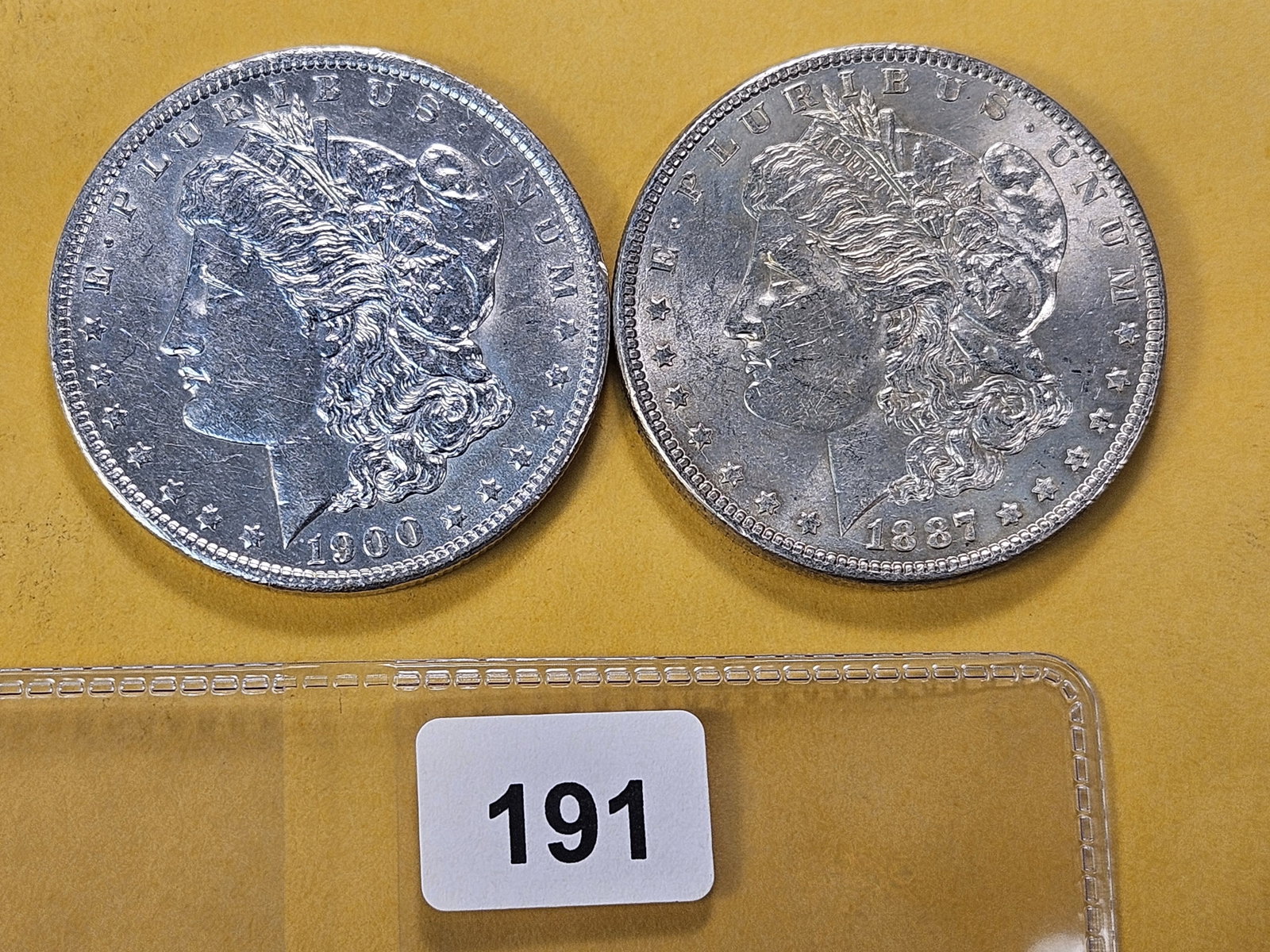 Two About Uncirculated Morgan Silver Dollars: 1887 and 1900-O