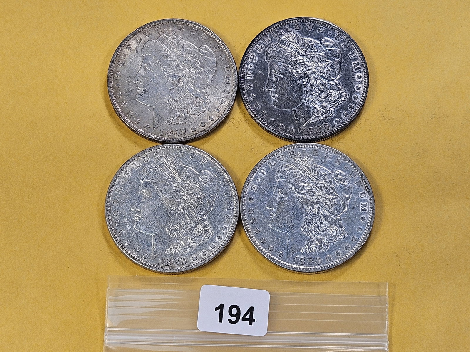 Four Morgan Silver Dollars: 1880, 1883, 1897 and 1900