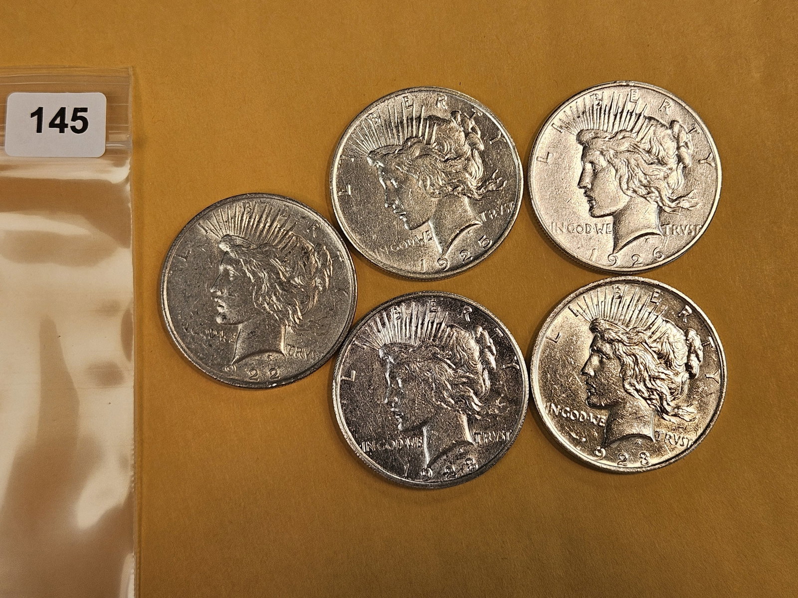 Five mixed Peace Silver Dollars: Mixed dates and grades