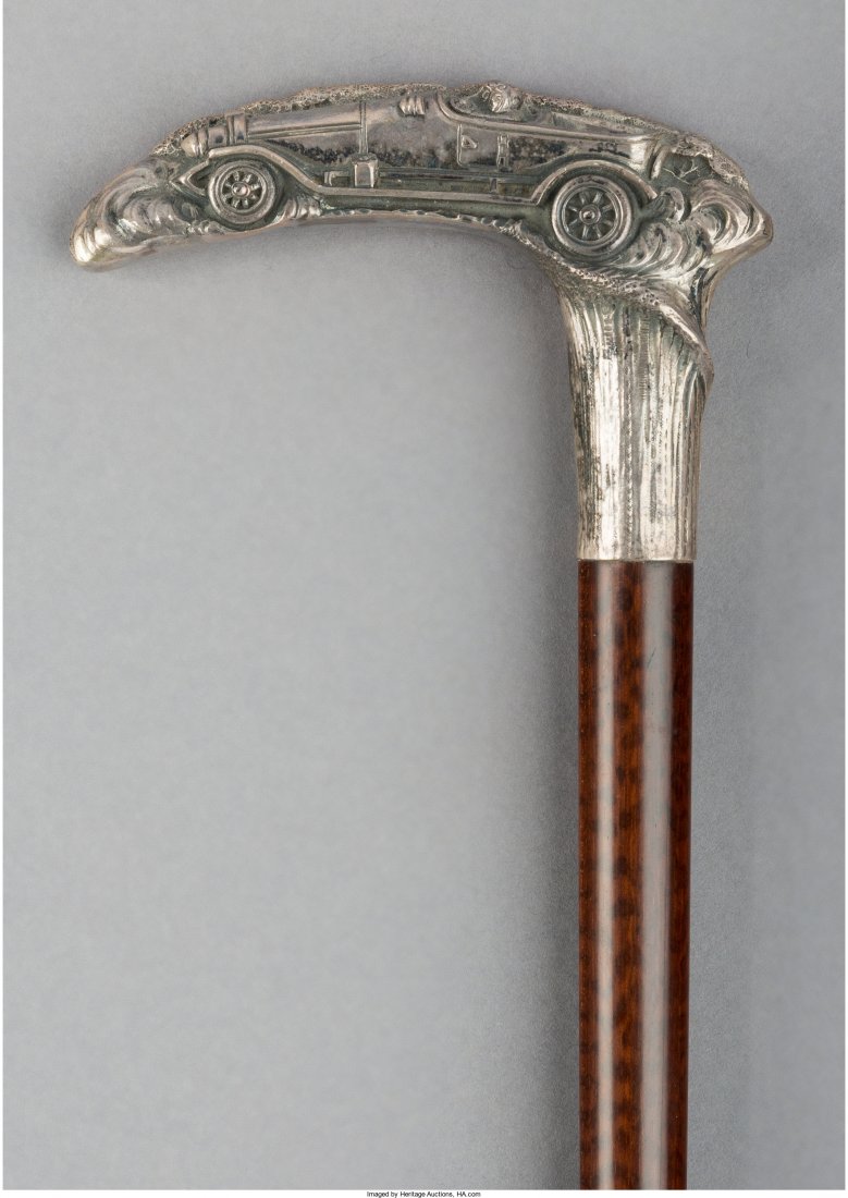 A Mahogany and German Silver-Mounted Cane with: A Mahogany and German Silver-Mounted Cane with Automobile Racing Motif, circa 1920 Marks to handle: (crescent), (crown), 800 35-1/2 inches high x 4-1/2 inches wide (90.2 x 11.4 cm) HID04901242017