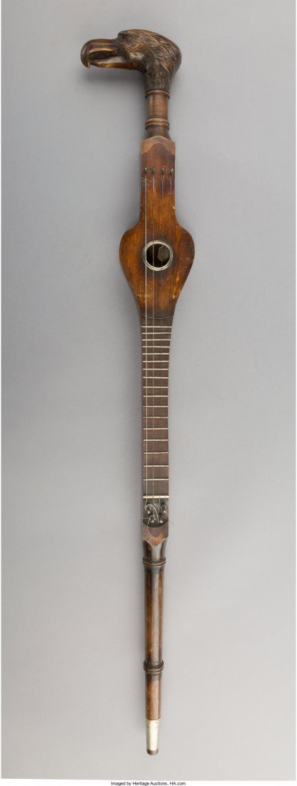 A Continental Carved Fruitwood Guitar, early 20th: A Continental Carved Fruitwood Guitar, early 20th century 35-1/4 inches (89.5 cm) Property from the Collection of Mr. Kenneth W. Davis, Fort Worth, Texas The carved wood eagle form handle is fastened 