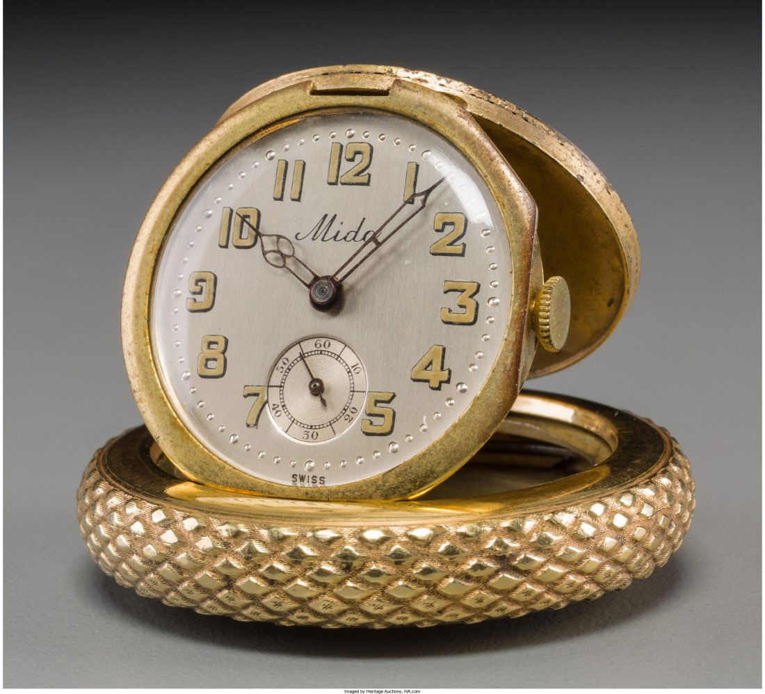 A Silver and Gold-Plated Mido Automobile Tire Travel: A Silver and Gold-Plated Mido Automobile Tire Travel Clock Marks to interior: NIEL HF, BREVET DEM, METAL PLAQUE OR GALVANIQUE GARANTI 10 ANS, MODEL DEPOSE 1-3/4 inches high (4.4 cm) Property from the