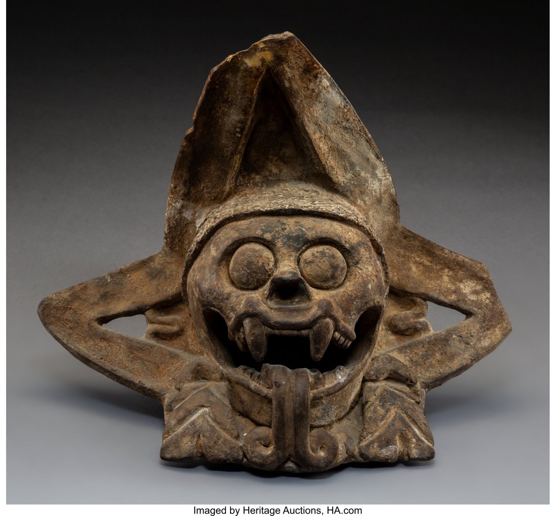 A Post-Classic, Toltec/Aztec Death Head c. 1200-: A Post-Classic, Toltec/Aztec Death Head c. 1200-1500 AD Earthenware variegated brown color, slab built and the raised death's head with bulging eyes, open mouth showing fangs and a bifurcated serpent 