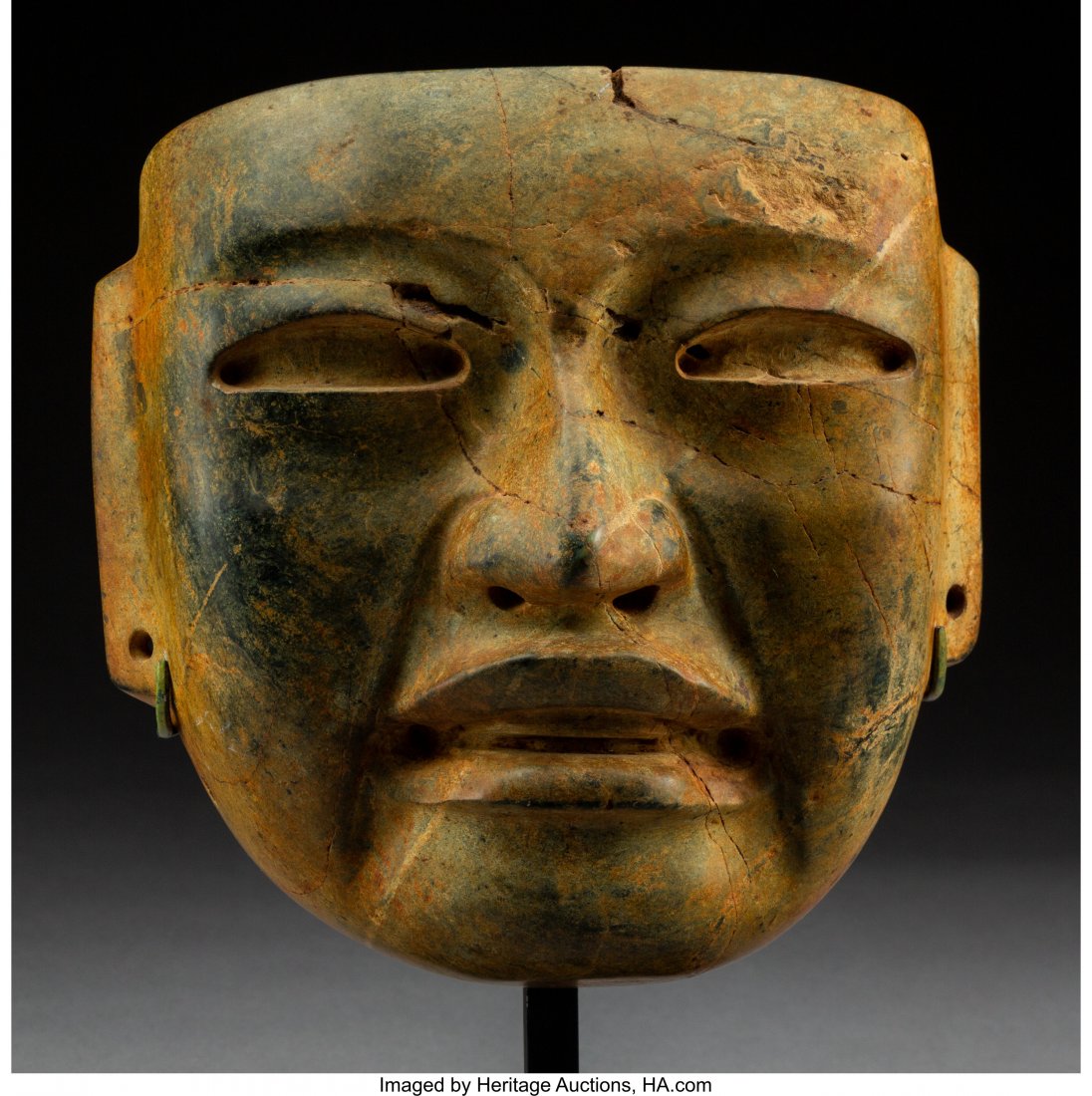 An Important Olmec Mask c. 300-500 BC Green s: An Important Olmec Mask c. 300-500 BC Green serpentine with staining from red pigment (probably cinnabar). The life-size mask with finely carved facial features in high relief, portraying a youthful,