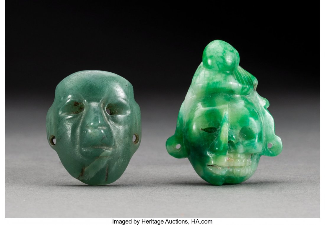 Two Miniature Pre-Columbian Heads c. 500 BC - 14: Two Miniature Pre-Columbian Heads c. 500 BC - 1400 AD One a Maya or Aztec head divided down the middle between skull and flesh, carved of mottled apple green jade; the other an Olmec miniature mask ca