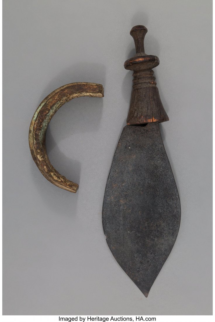 Two African Metal Items including a Nigeria ca: Two African Metal Items including a Nigeria cast ingot and a Congo blade with wood handle Provenance: Dr. & Mrs. John Finley Lengths: 5 ¾ and 14 inches HID03101242017
