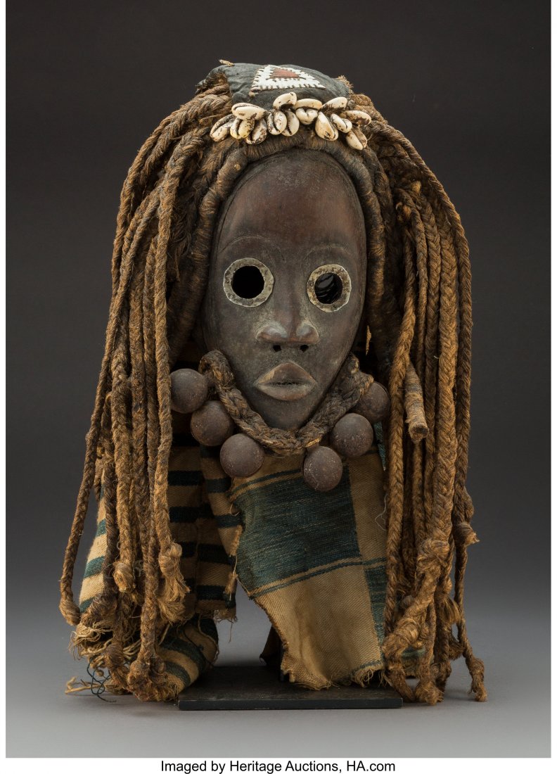 A Dan Mask with Attached Beard, Bells, and Fiber: A Dan Mask with Attached Beard, Bells, and Fiber Wig and Cloth Headdress with a custom metal base Height: 11 inches HID03101242017