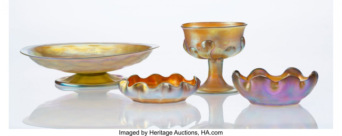 Four Tiffany Studios Favrile Glass Table Article: Four Tiffany Studios Favrile Glass Table Articles, early 20th century Marks: L.C.T., (various) 2 x 7-1/2 inches (5.1 x 19.1 cm) (largest, compote) A COLLECTION OF STEUBEN AND TIFFANY GLASS FROM A MIDW