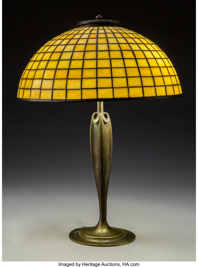 A Tiffany Studios Leaded Glass and Bronze Geomet: A Tiffany Studios Leaded Glass and Bronze Geometric Table Lamp, circa 1910 Marks to shade: TIFFANY STUDIOS N.Y. 1421 Marks to base: TIFFANY STUDIOS, NEW YORK, 615 18-1/2 x 14 inches (47.0 x 35.6 cm) H