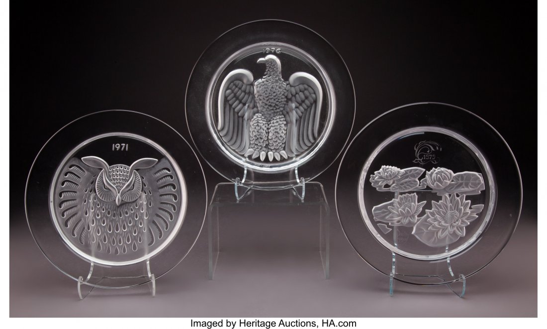 A Group of Two Lalique Glass Plates and a Daum G: A Group of Two Lalique Glass Plates and a Daum Glass Plate, circa 1971-1979 Marks to largest: Daum, France, 2343/4000 8 inches (20.3 cm) (largest) The group comprising: 1 Lalique 1976 Aigle annual pla