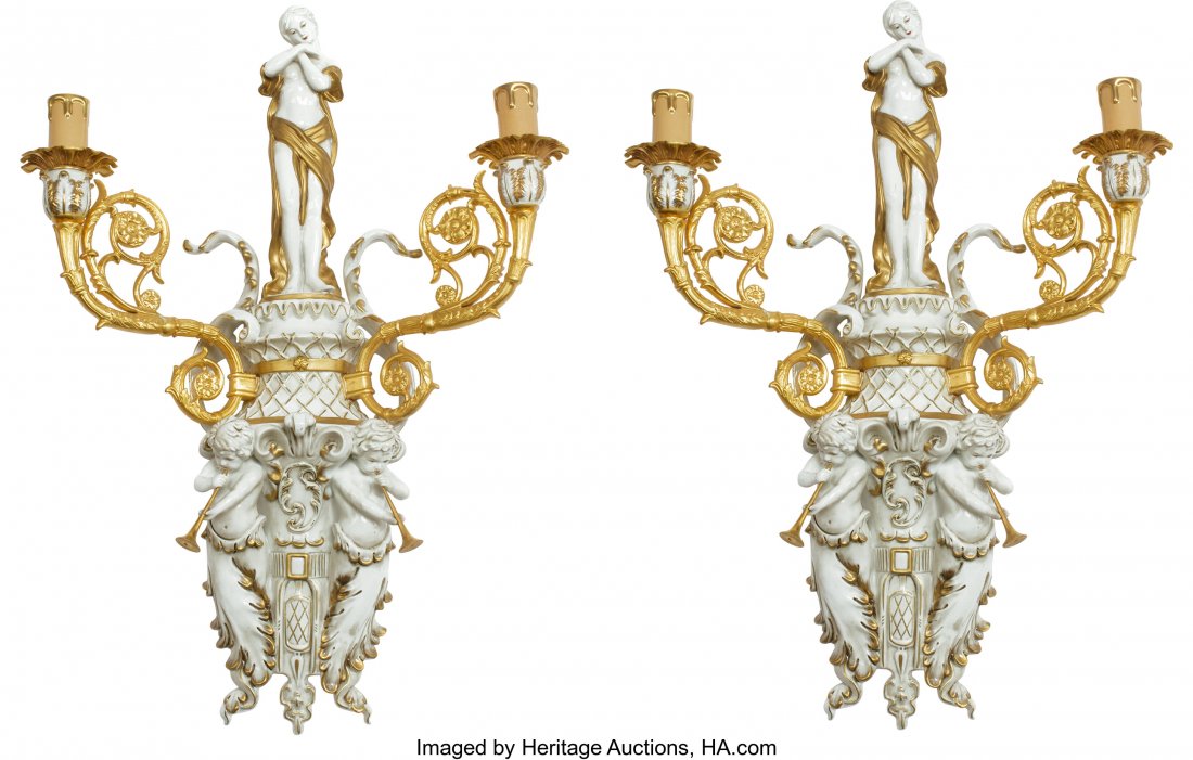A Pair of German Gilt Bronze and Porcelain Two-L: A Pair of German Gilt Bronze and Porcelain Two-Light Wall Sconces 27-1/2 x 20 x 7-1/2 inches (69.9 x 50.8 x 19.1 cm) (each) Each sconce of grotesque style, surmounted by maiden-form finials, with net 