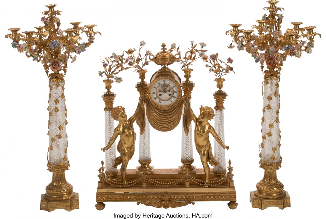A French Louis XV-Style Three-Piece Gilt Bronze : A French Louis XV-Style Three-Piece Gilt Bronze and Cut Crystal Clock Garniture 33 x 28 x 8 inches (83.8 x 71.1 x 20.3 cm) (clock) 40 x 18 inches (101.6 x 45.7 cm) (garnitures) The clock and two cande