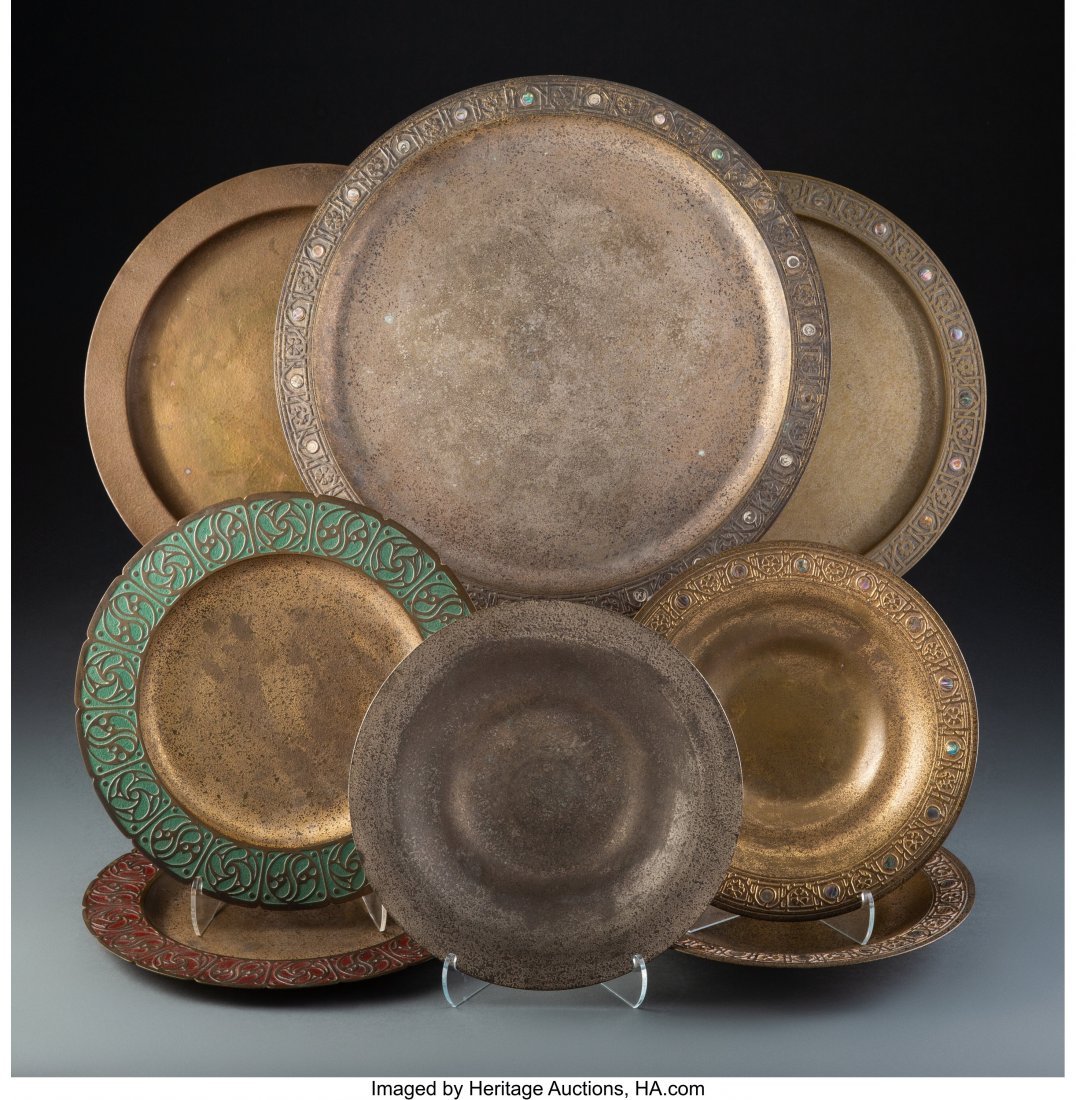 Group of Eight Tiffany Studios Gilt Bronze Table: Group of Eight Tiffany Studios Gilt Bronze Table Articles, circa 1920 Marks: TIFFANY STUDIOS, NEW YORK, (various) 14 inches (35.6 cm) (largest charger) The group comprising: 2 enameled plates, 1612A; 