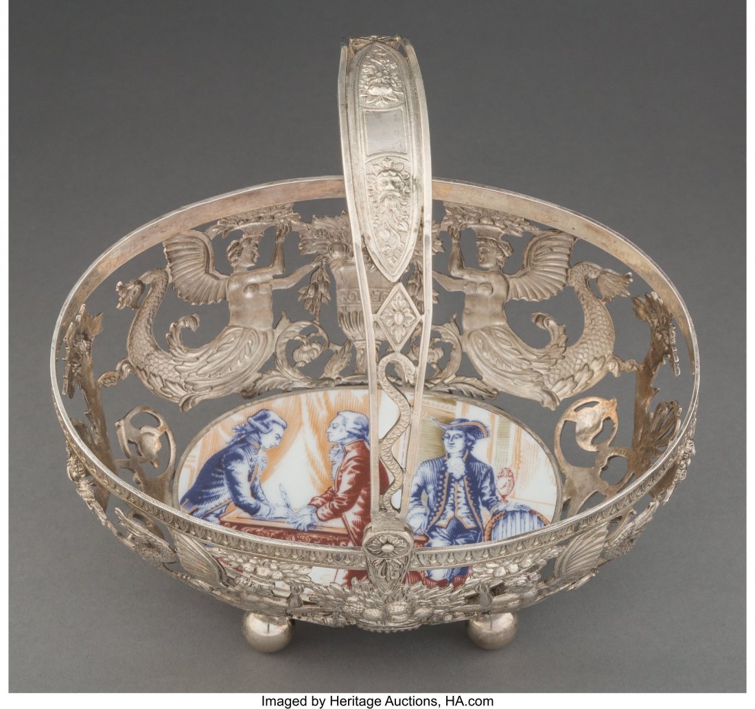 A German Reticulated Silver and Porcelain Basket: A German Reticulated Silver and Porcelain Basket, 19th century Marks: (crescent-crown), 800, (J-swan-K), (various pseudo-marks) 6-1/2 x 4-1/2 x 7-1/2 inches (16.5 x 11.4 x 19.1 cm) (with handle raised