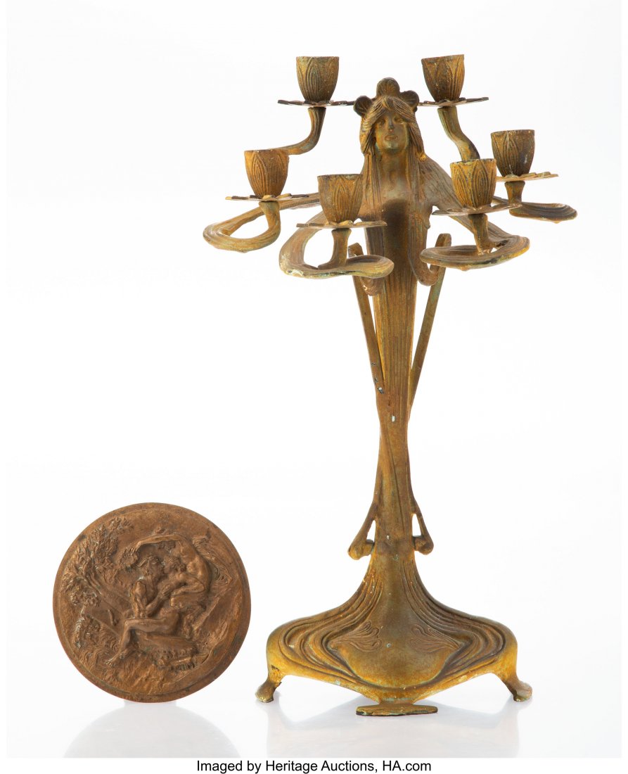 An Art Nouveau-Style Bronze Figural Candelabra a: An Art Nouveau-Style Bronze Figural Candelabra and a Bronze Erotic Medallion, 20th century 18 x 10-1/2 x 9 inches (45.7 x 26.7 x 22.9 cm) HID03101062020 © 2020 Heritage Auctions | All Rights Rese