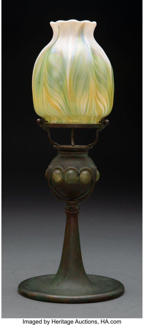 A Tiffany Studios Favrile Glass and Patinated Br: A Tiffany Studios Favrile Glass and Patinated Bronze Candlestick Lamp, circa 1910 Marks to base: TIFFANY STUDIOS, NEW YORK, 1210 Marks to shade: LCT 13-3/4 inches (34.9 cm) HID03101062020 © 2020 
