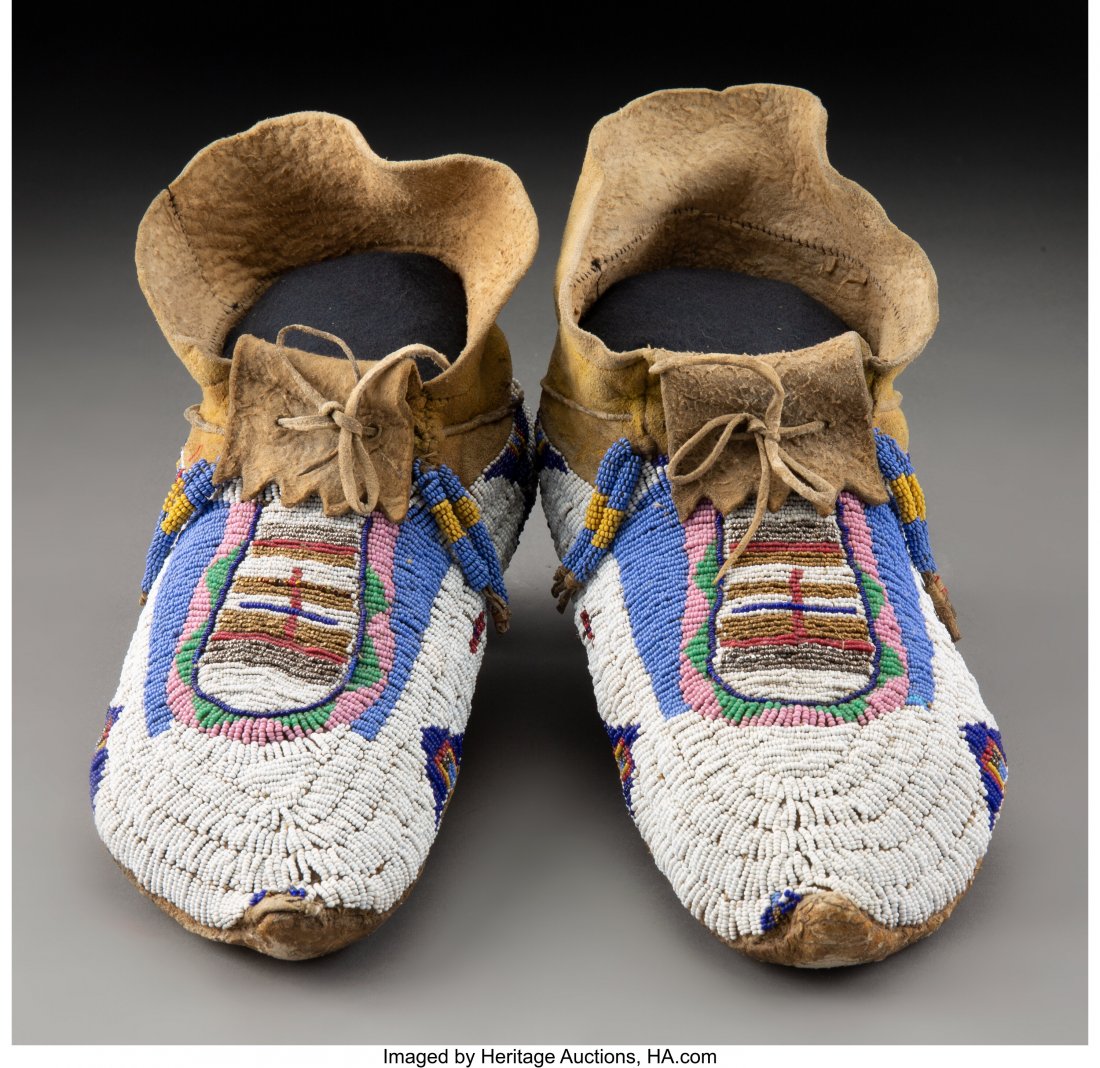 A Pair of Ute Beaded Hide Moccasins c. 1890 hi: A Pair of Ute Beaded Hide Moccasins c. 1890 hide, yellow ochre pigment, metal and glass seed beads, sinew Provenance: From the L. D. Bax Collection Lengths: 11 inches each HID03101062020 © 2020 H