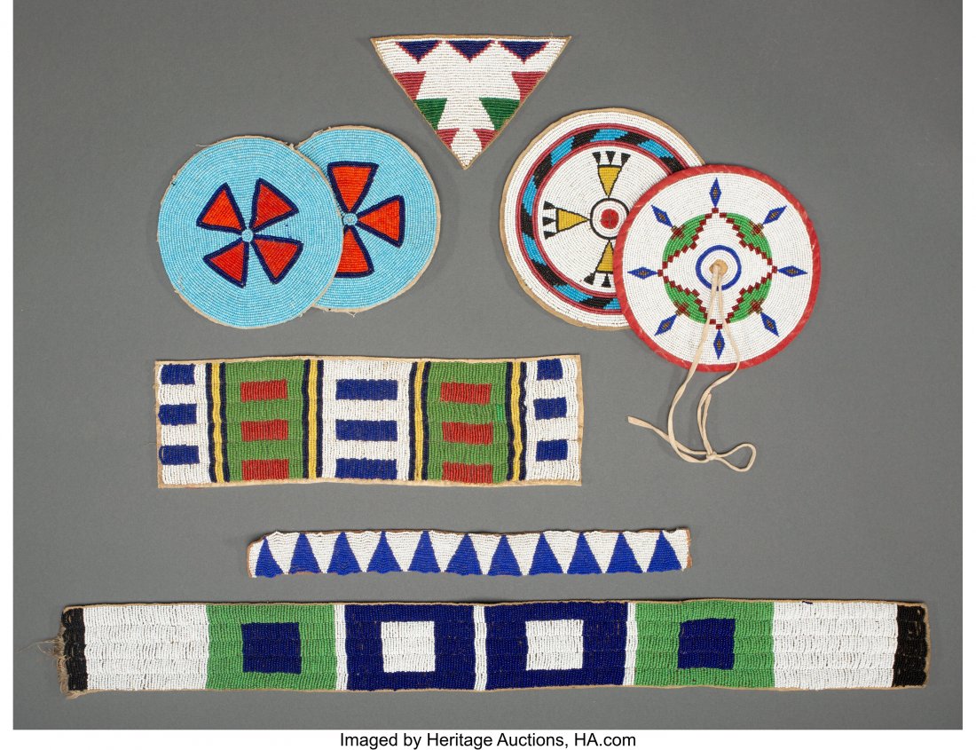 Eight Plains Beaded Hide Items c. 1890 - 1930 : Eight Plains Beaded Hide Items c. 1890 - 1930 including a triangular panel, four rosettes, and three strips, hide, red ochre pigment, canvas, brass and glass seed beads, cotton cloth, muslin, sinew, t