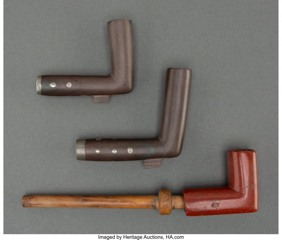 A Sioux Woman's Pipe and Two Cree Pipe Bowls c.: A Sioux Woman's Pipe and Two Cree Pipe Bowls c. 1890 together with three pipe stems; Catlinite, wood, blackstone, lead Provenance: From the L. D. Bax Collection Length of pipe: 6 &frac12; inches H