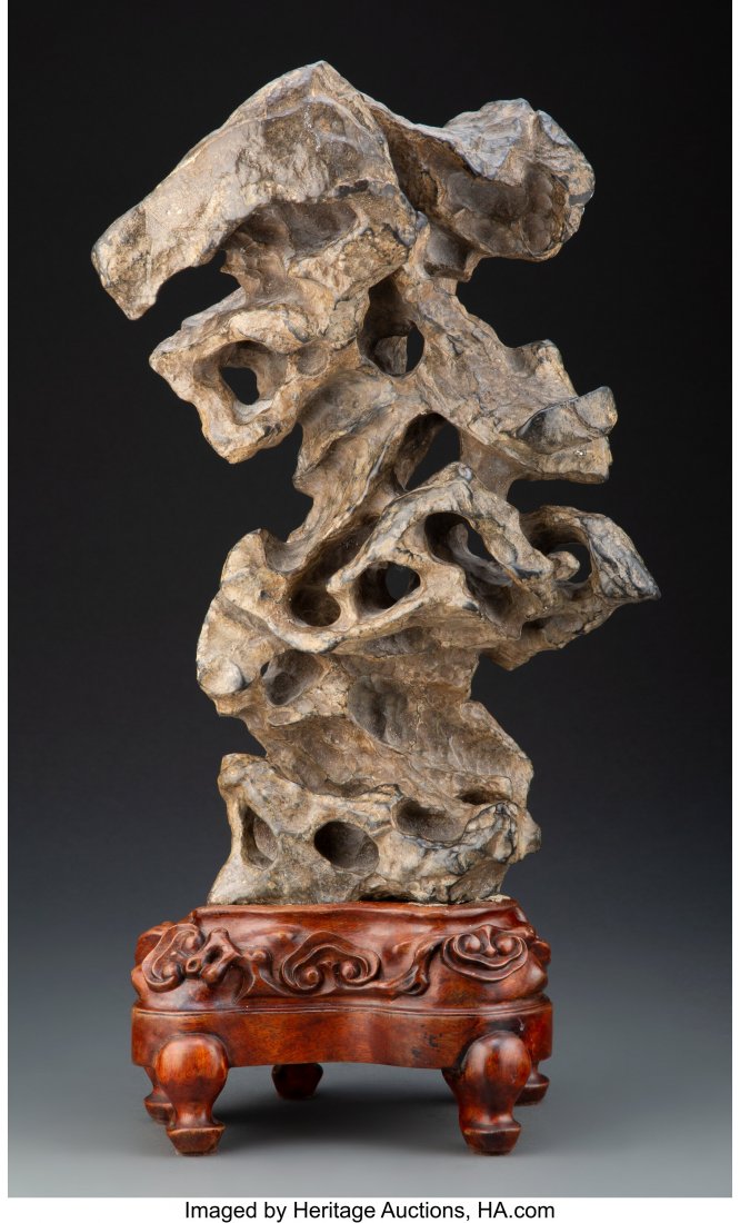 A Chinese Scholar's Rock on Carved Hardwood Stan: A Chinese Scholar's Rock on Carved Hardwood Stand 15-1/2 x 9-1/2 inches (39.4 x 24.1 cm) (rock, excluding stand) Overall height including stand: 19-1/8 inches high (48.6 cm) HID03101062020 © 2020