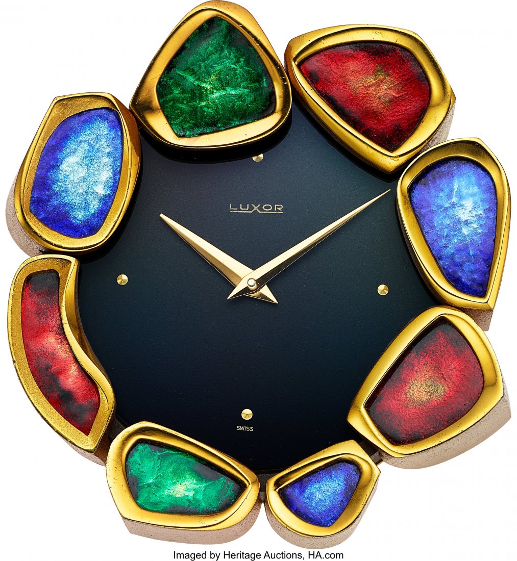 Luxor, Swiss Enameled 8 Day Desk Clock Case: 3: Luxor, Swiss Enameled 8 Day Desk Clock Case: 3 3/4 inches, gilt metal, inclined case when on a desk, translucent enameled "leaves" for the bezel in green, red and blue, No. 1702 Dial: matte black, gol
