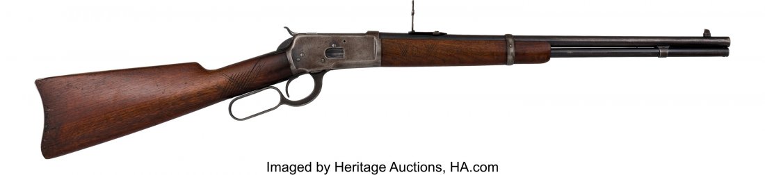 Winchester Model 92 Saddle Ring Carbine. Seria: Winchester Model 92 Saddle Ring Carbine. Serial no. 960809, .25-20 W.C.F. caliber, 20-inch barrel with fixed front sight and rear folding ladder sight. Blued finish. Saddle ring. Custom checkered waln